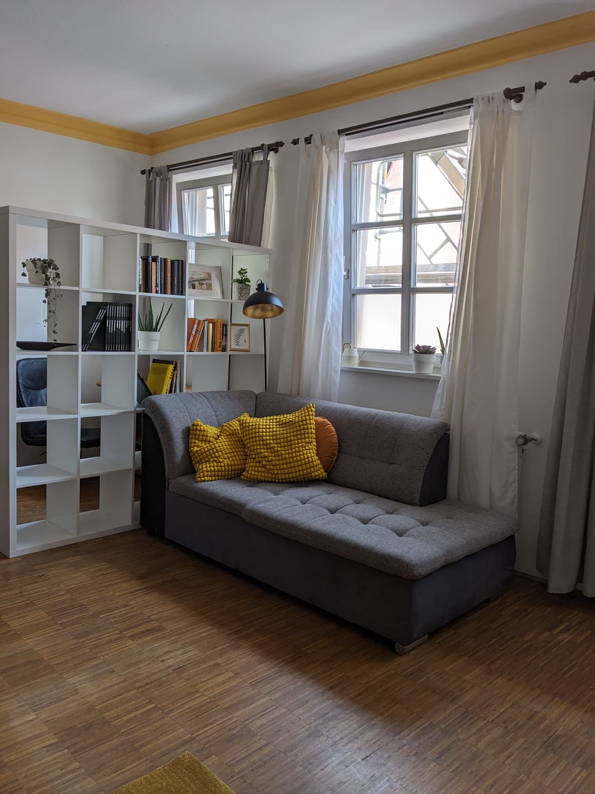 Wohnzimmer mit gelben Akzenten und Sprossenfenstern